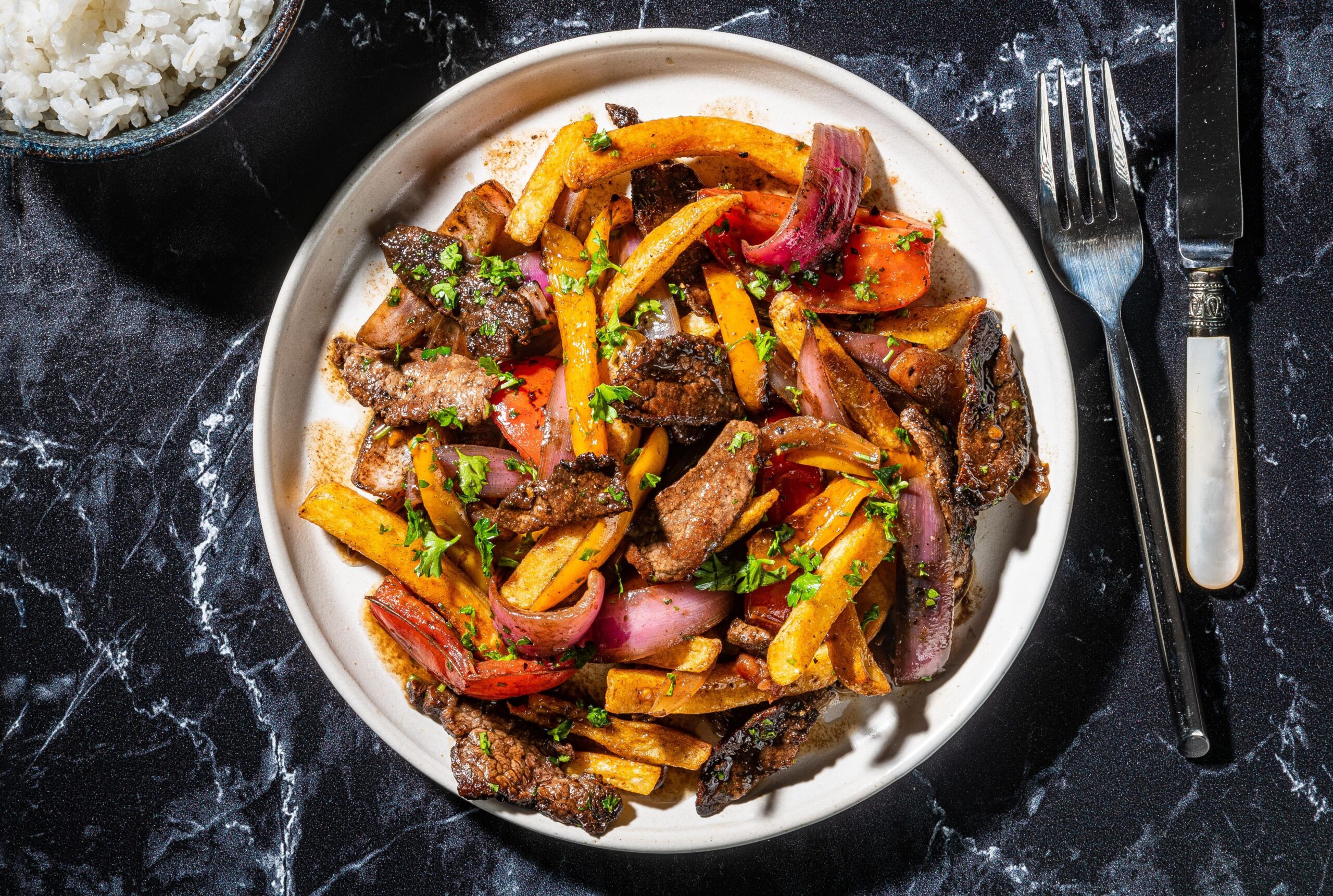  A colorful plate filled with fresh veggies, tender beef, and crispy french fries